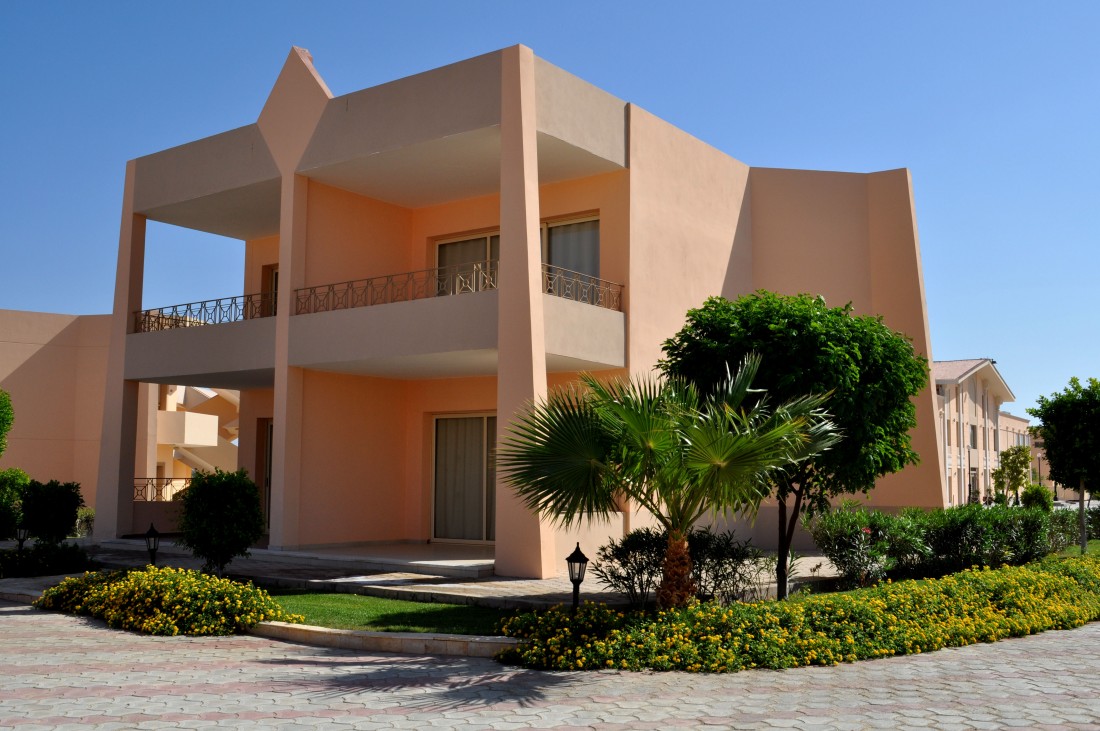 Pastel villa exterior with wrought-iron balconies